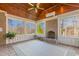 Sunroom with brick fireplace, vaulted ceilings, large windows, and tile flooring at 4109 Cheek Point Pl, Burlington, NC 27215