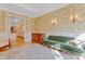 Living room with hardwood floors, green sofa, and view into the kitchen at 4137 Gardenlake Dr, Raleigh, NC 27612