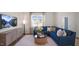Cozy living room with a blue sectional sofa, wood coffee table, and large window at 466 Belgian Red Way, Wake Forest, NC 27587