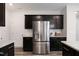 Kitchen with stainless steel refrigerator, dark cabinets, and granite countertops at 502 Hester Rd, Durham, NC 27703