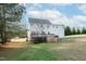 Backyard view of a two-story home with a deck, surrounded by a grassy yard and trees at 1205 Golden Field Dr, Knightdale, NC 27545