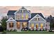 Two-story home with gray siding, stone accents, and a landscaped lawn at 259 August Trce Dr, Pittsboro, NC 27312