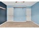 Bedroom with blue walls, two closets and floating shelves at 1308 Fenwick Pkwy, Durham, NC 27713