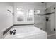 Bathroom with a soaking tub, glass shower, and updated fixtures at 2416 Laurelford Ln, Wake Forest, NC 27587