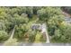 Aerial view of house nestled in a wooded area with a gravel driveway at 3423 Iva Ada Dr, Hillsborough, NC 27278