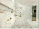 Spa-like shower with marble walls and gold fixtures at 4139 Rockingham Dr, Raleigh, NC 27609