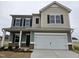 Two-story house with gray siding, white garage door, and landscaping at 82 Vili Dr, Broadway, NC 27505