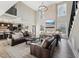 Two-story living room with a stone fireplace, leather furniture, and large windows at 2418 Crossroads Ave, Hillsborough, NC 27278