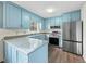 Bright kitchen features light blue cabinets, stainless steel appliances, and a breakfast bar at 312 Burkwood Ln, Raleigh, NC 27609