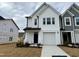 Two-story townhome with white siding and a gray accent wall at 523 Eversden Dr, Zebulon, NC 27597