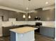 Modern kitchen with gray cabinets, granite countertops, and an island at 523 Eversden Dr, Zebulon, NC 27597