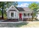 Charming gray house with red door, brick steps, and landscaped lawn at 3612 Ladywood Ct, Raleigh, NC 27616