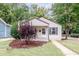One-story home with a covered porch, landscaping, and a rainbow flag at 810 Brooklyn St, Raleigh, NC 27605