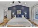 Spacious main bedroom with a navy blue accent wall, hardwood floors, and large windows at 810 Brooklyn St, Raleigh, NC 27605