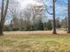 Landscaped backyard with trees and golf course views at 191 Pine Lake Dr, Siler City, NC 27344