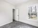 Simple bedroom with large window, closet, and grey tile floor at 191 Pine Lake Dr, Siler City, NC 27344