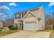 Two-story house with beige vinyl siding, a white garage door, and a landscaped yard at 722 Blue Lake Dr, Mebane, NC 27302