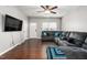 Spacious living room featuring hardwood floors, large TV, and comfortable sectional sofa at 722 Blue Lake Dr, Mebane, NC 27302