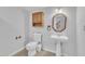 Clean bathroom with pedestal sink, toilet, and wooden cabinet at 101 Creekside Dr, Selma, NC 27576