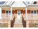 Inviting front porch with brick steps and white columns at 101 Creekside Dr, Selma, NC 27576