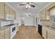 Eat-in kitchen with hardwood floors, white appliances, and access to deck at 101 Creekside Dr, Selma, NC 27576