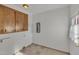 Laundry room with wood cabinets and tile floor at 101 Creekside Dr, Selma, NC 27576