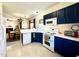 Kitchen boasts white appliances, dark blue cabinetry and view to dining area at 1205 Red Ash Cir, Durham, NC 27704