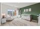 Bright Bedroom with green accent wall, crib, rocking chair, and bookshelf at 125 Windrush Ln, Durham, NC 27703