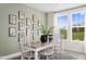 Bright dining room with white table and chairs, botanical art, and large windows at 59 Honeydew Way # 140, Clayton, NC 27520