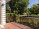 A red brick porch with an iron railing overlooking a tree-lined street at 808 W Willowbrook Dr, Burlington, NC 27215