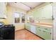 Kitchen with light green cabinets, dishwasher, and gas range at 100 E Rockway St, Durham, NC 27704