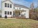 Two-story house with beige siding, a covered porch, and a brick patio at 112 Roundrock Ln, Sanford, NC 27330