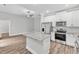 Modern kitchen with white cabinets, granite countertops, and stainless steel appliances at 208 Brickwell Way, Youngsville, NC 27596