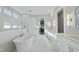 Luxurious bathroom with a freestanding tub, double vanity, and marble floors at 235 Cottage Way, Pittsboro, NC 27312
