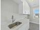 Laundry room with stainless steel sink and white cabinets at 235 Cottage Way, Pittsboro, NC 27312