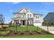 Two-story house with gray siding, stone accents, and a three-car garage at 111 E Fountainhead Ln # 154, Garner, NC 27529