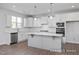 Modern kitchen with white cabinets, island, stainless steel appliances, and hardwood floors at 409 Reinsman Ct, Mebane, NC 27302