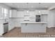 Modern kitchen with white cabinets, a large island, and stainless steel appliances at 409 Reinsman Ct, Mebane, NC 27302