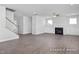 Open living room with hardwood floors, fireplace, and staircase at 409 Reinsman Ct, Mebane, NC 27302