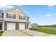 Two-story townhome with two-car garage, stone accents, and landscaping at 5512 Henley Ridge Dr # 191, Graham, NC 27253