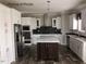 Modern kitchen with white cabinets, an island, and stainless steel appliances at 6016 Charlies Deadend Rd, Efland, NC 27243