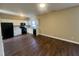 Open kitchen with white cabinets, black appliances, and hardwood floors at 7041 Spanglers Spring Way, Raleigh, NC 27610