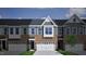 Two story townhome with gray and brick exterior, two-car garage, and landscaping at 1034 Westerland Way # 210, Durham, NC 27703
