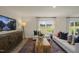 Living room with a white sofa, wood coffee table, and large windows at 113 Reagan Crest Dr, Clayton, NC 27520