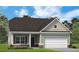 One-story home with gray siding, white garage door, and landscaping at 134 Knoll Way, Sanford, NC 27332