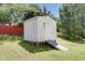 White storage shed with a ramp in a grassy backyard at 1732 Great Bend Dr, Durham, NC 27704