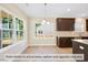 Bright eat-in kitchen with large windows and dark cabinets at 1981 Meadowview Dr, Graham, NC 27253