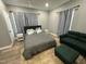 Comfortable bedroom with gray bedding and a green couch at 432 N Chestnut St, Henderson, NC 27536