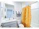 Small bathroom with white vanity, toilet, and yellow shower curtain at 507 Fife Ct, Gibsonville, NC 27249