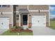 Townhome entrance with black door and white double garage door at 508 Fife Ct, Gibsonville, NC 27249